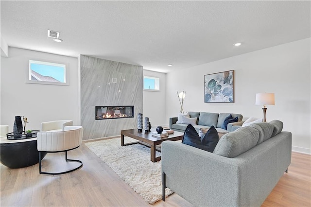 living room featuring light hardwood / wood-style floors and a high end fireplace