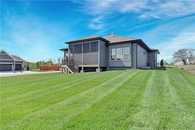 rear view of house featuring a yard and a sunroom