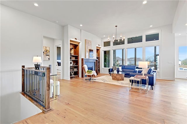 17433 Gillette St, Overland Park, KS 66221 - living area with light wood-style floors, recessed lighting, a chandelier, and a fireplace