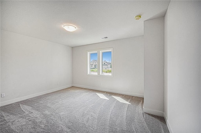 spare room with carpet and a textured ceiling