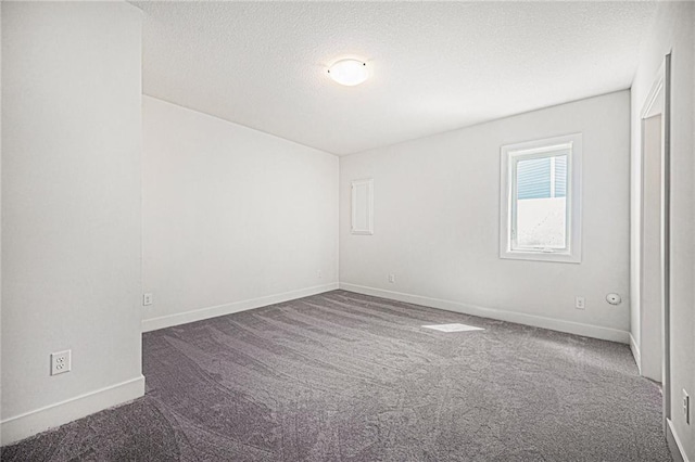 carpeted empty room with a textured ceiling