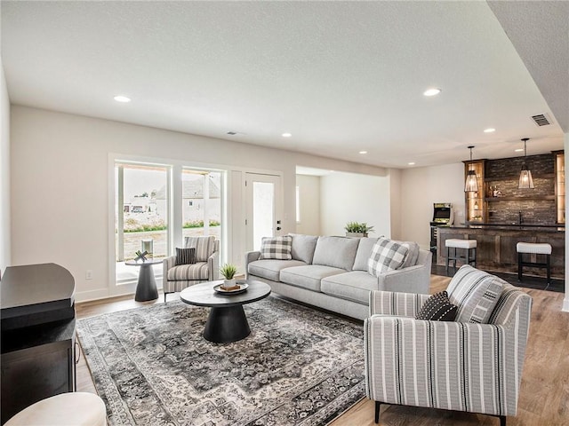 living room featuring wood-type flooring and a textured ceiling