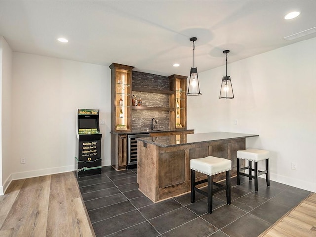 bar with sink, wine cooler, dark hardwood / wood-style flooring, decorative backsplash, and hanging light fixtures