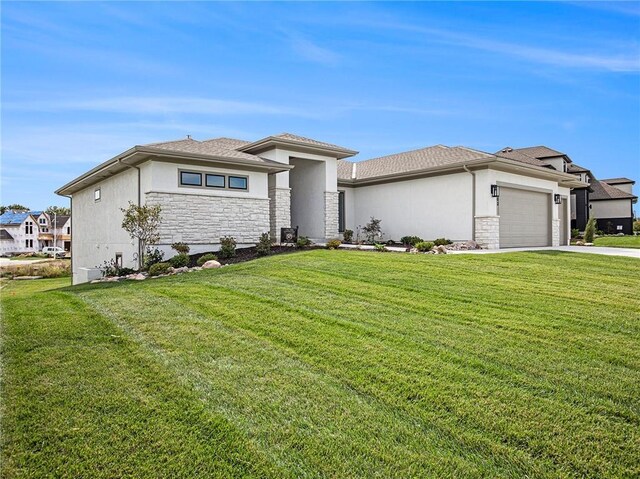 prairie-style house featuring a garage and a front lawn