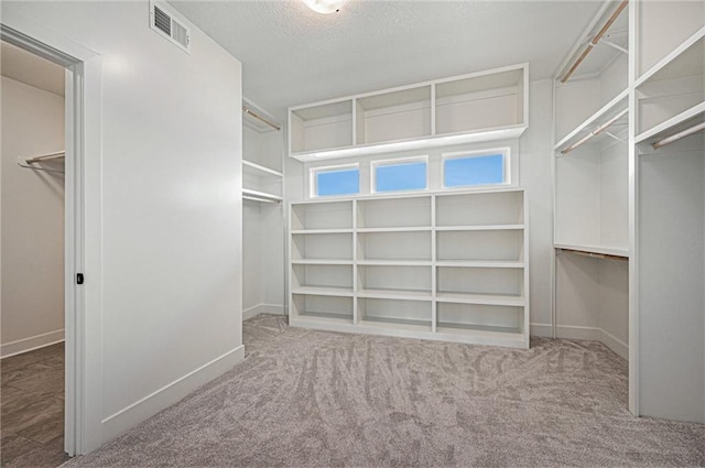 walk in closet featuring carpet flooring and visible vents