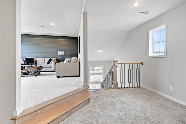 sitting room with carpet, a healthy amount of sunlight, and vaulted ceiling