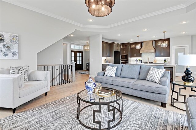 17421 Gillette St, Overland Park, KS 66221 - living room featuring light wood-style floors, ornamental molding, recessed lighting, baseboards, and a chandelier