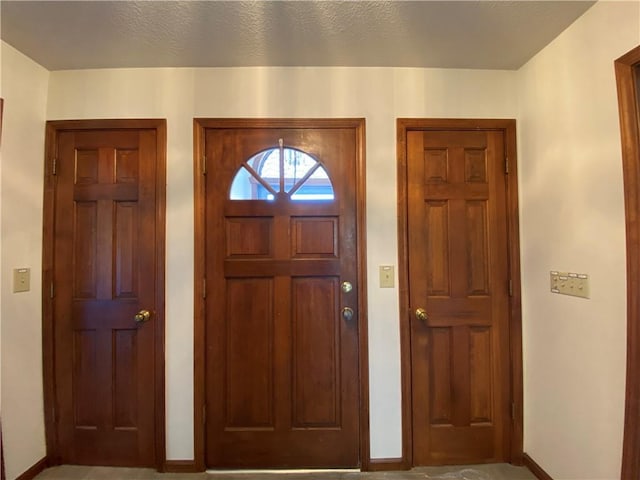 entryway with a textured ceiling and baseboards