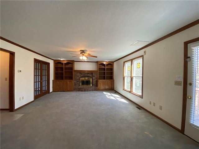 unfurnished living room featuring baseboards, french doors, a brick fireplace, carpet, and crown molding