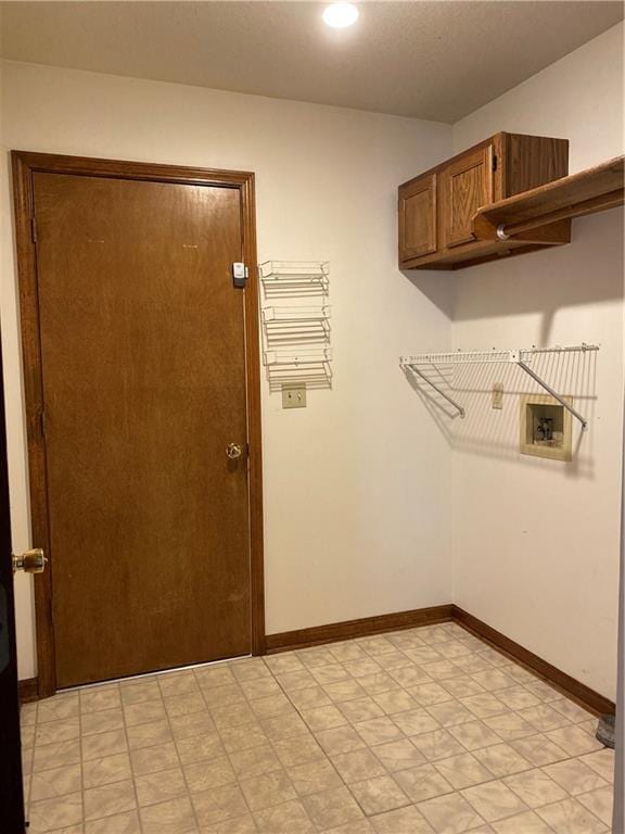 laundry area featuring cabinet space, baseboards, washer hookup, and light floors