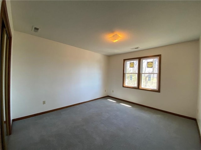 empty room featuring baseboards and visible vents