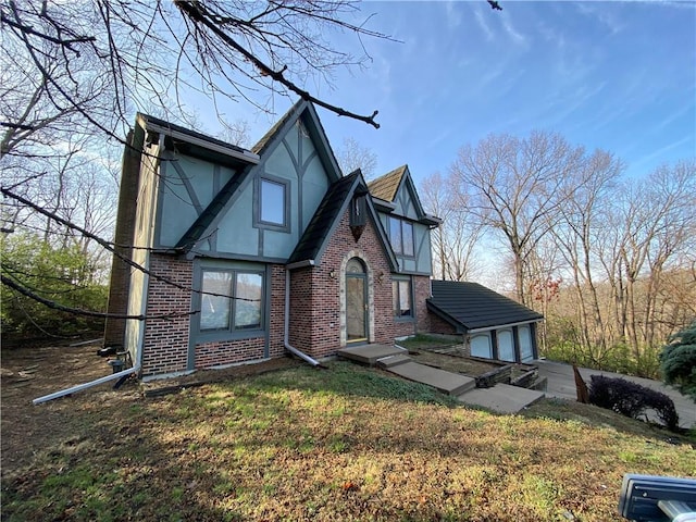 view of front facade featuring a front yard, brick siding, and stucco siding