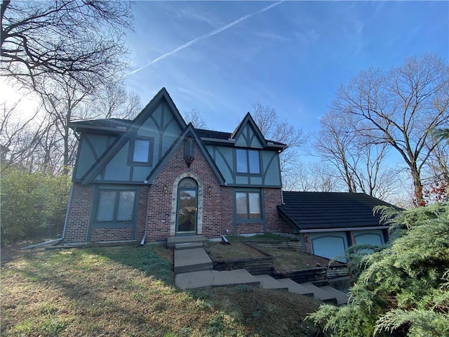 tudor home featuring brick siding and stucco siding