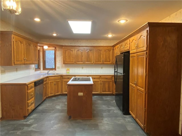 kitchen featuring a center island, stainless steel dishwasher, brown cabinetry, freestanding refrigerator, and a sink