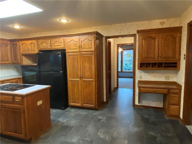 kitchen with black appliances, brown cabinets, and wallpapered walls