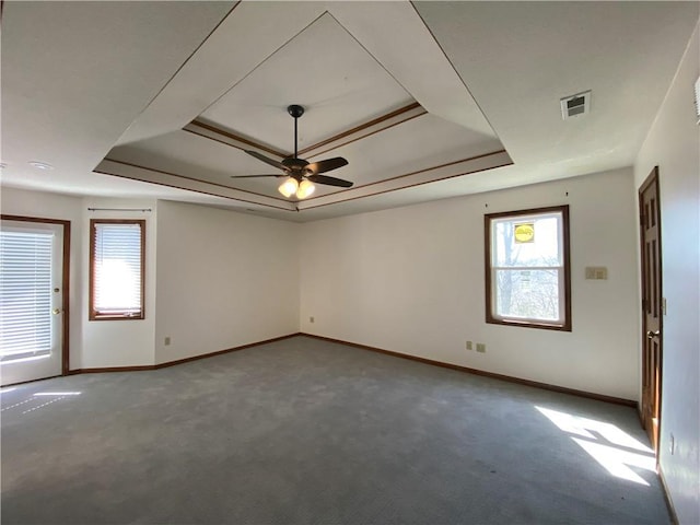 unfurnished room featuring carpet, a raised ceiling, visible vents, and baseboards