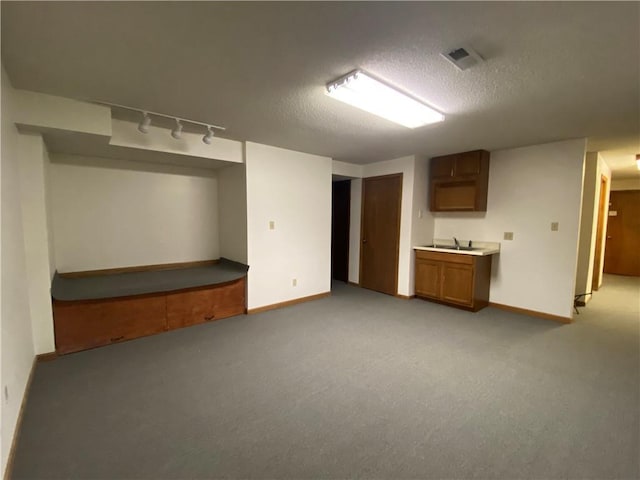 interior space with visible vents, light colored carpet, a textured ceiling, and baseboards