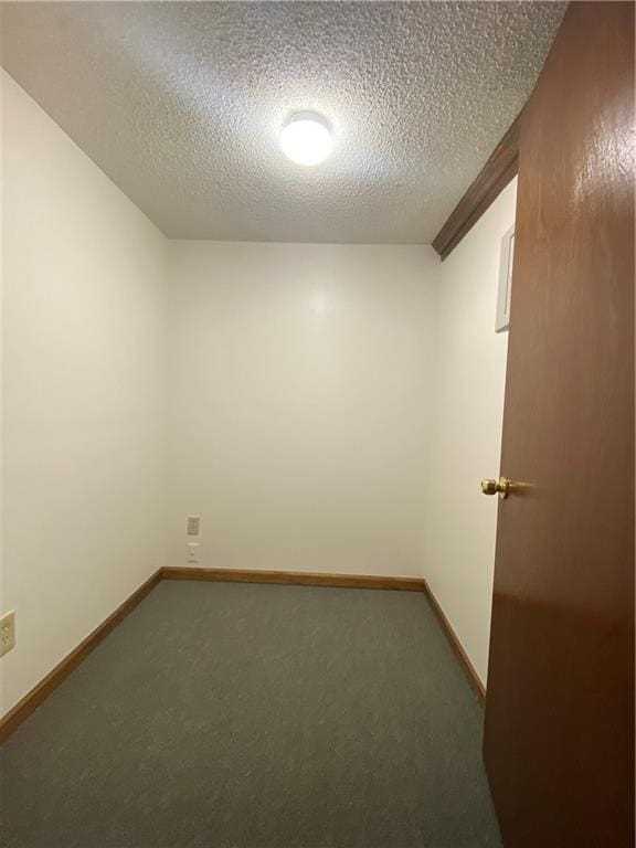 unfurnished room with a textured ceiling, baseboards, and carpet flooring