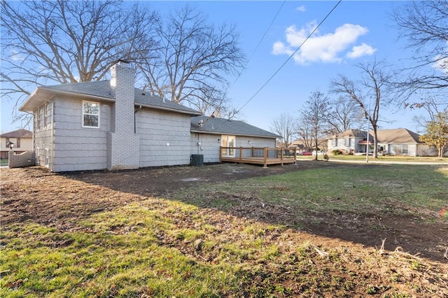 back of house featuring a wooden deck and a yard