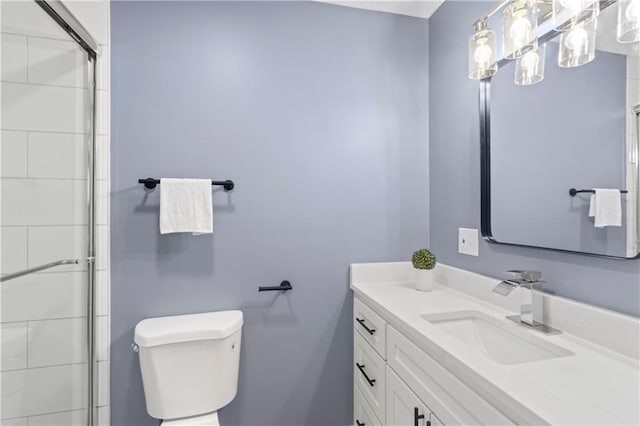 bathroom featuring toilet, vanity, and an enclosed shower