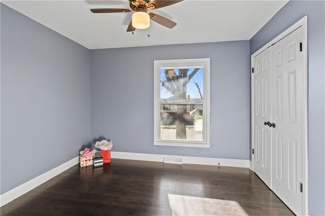 unfurnished room with dark hardwood / wood-style flooring and ceiling fan