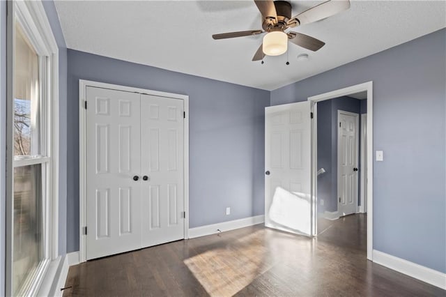 unfurnished bedroom featuring a closet, dark hardwood / wood-style floors, and ceiling fan