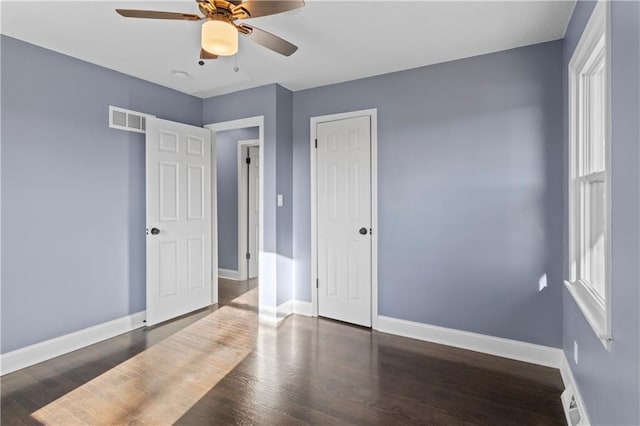 bedroom with ceiling fan, multiple windows, and dark hardwood / wood-style floors