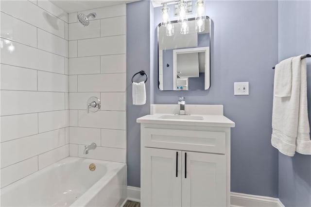 bathroom featuring tiled shower / bath and vanity