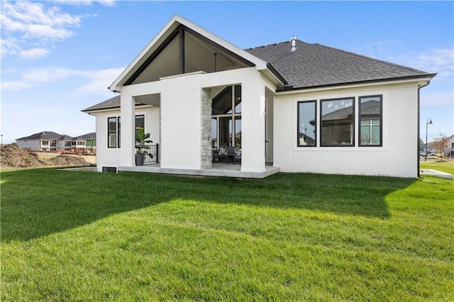 rear view of property featuring a lawn and a patio area