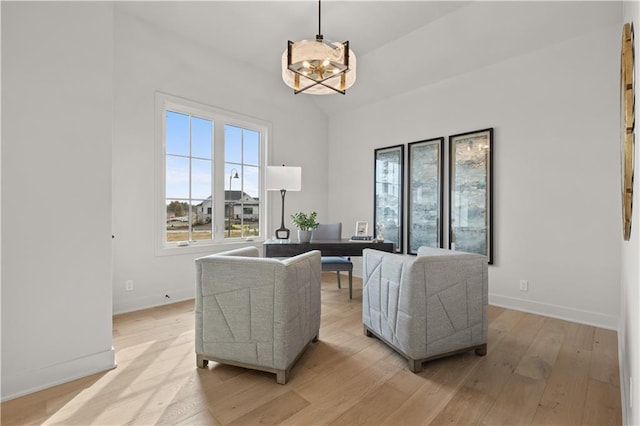 living room with a chandelier and light hardwood / wood-style floors