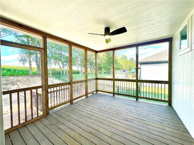 unfurnished sunroom featuring ceiling fan