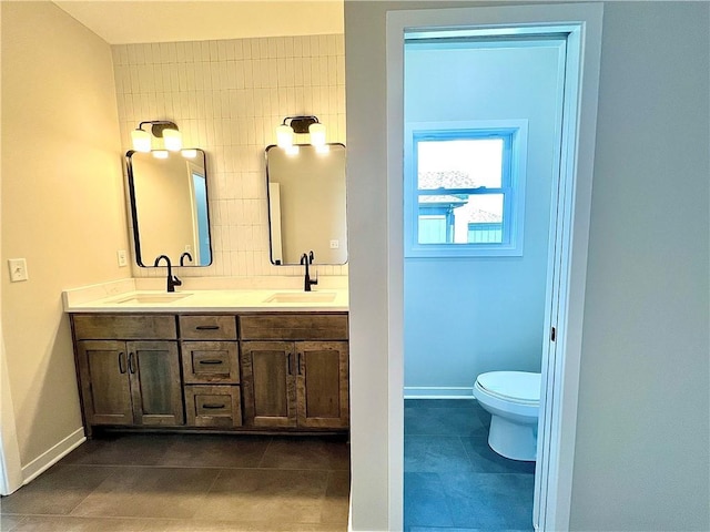 bathroom featuring tasteful backsplash, vanity, tile patterned floors, and toilet