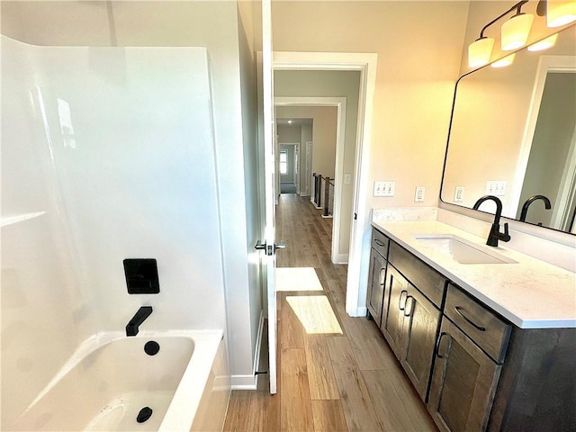 bathroom featuring wood-type flooring, vanity, and bathing tub / shower combination