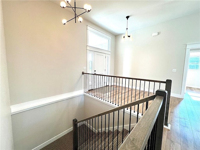 hallway featuring hardwood / wood-style floors and a chandelier