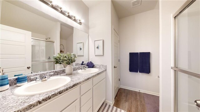 20385 W 193rd Ln, Spring Hill, KS 66083 - bathroom with double vanity, a shower with shower door, and wood finished floors