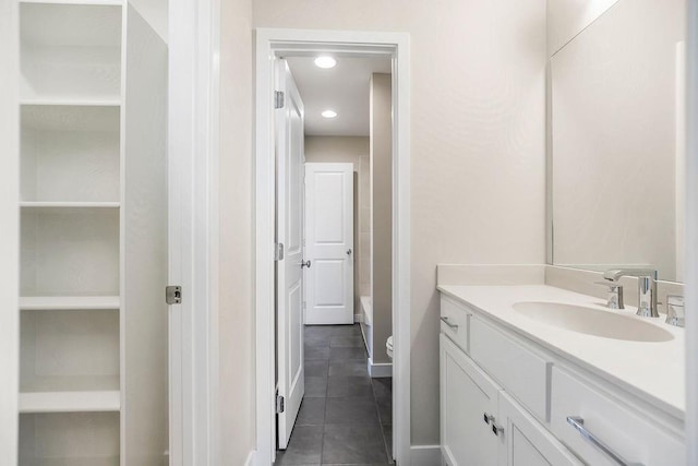 bathroom featuring vanity, tile patterned floors, a bathtub, and toilet