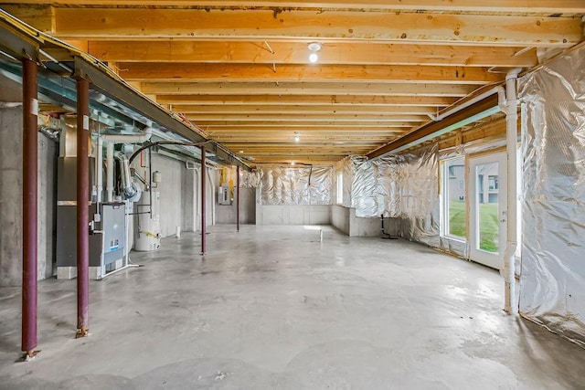 basement with heating unit, gas water heater, and electric panel