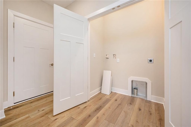 laundry area with hookup for an electric dryer and light hardwood / wood-style floors