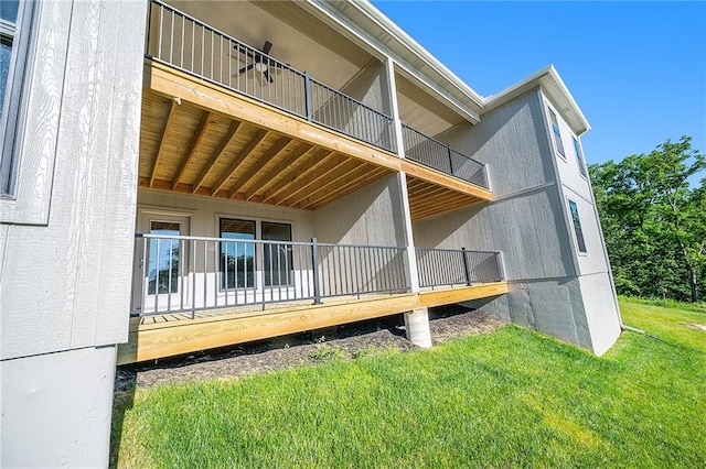 view of home's exterior featuring a lawn and a balcony