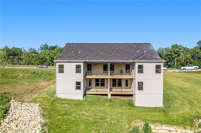 back of house with a balcony and a yard