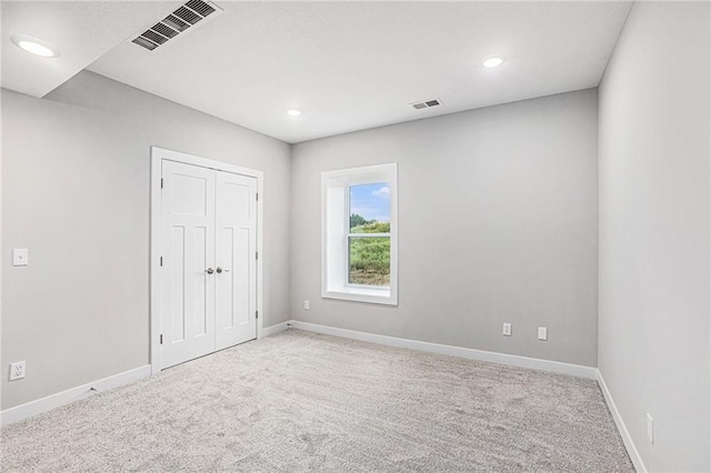 unfurnished room featuring light carpet