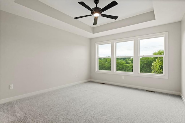 unfurnished room with carpet, a tray ceiling, and ceiling fan