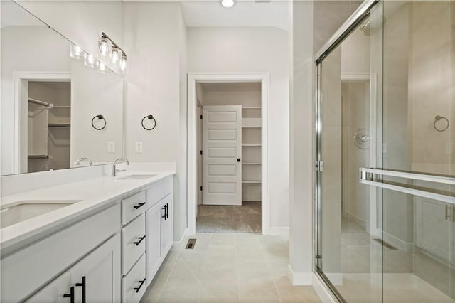 bathroom featuring walk in shower, vanity, and tile patterned floors