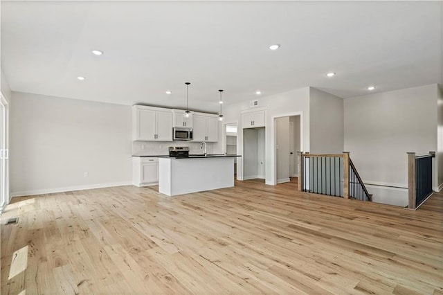 unfurnished living room featuring light hardwood / wood-style flooring and sink