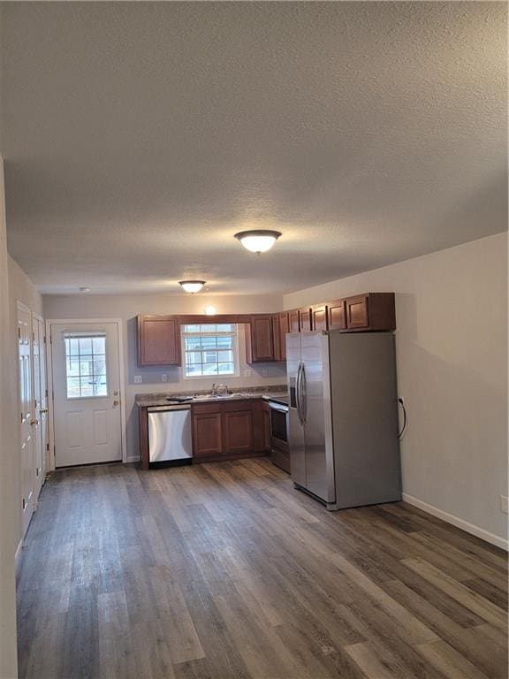 kitchen featuring sink, a textured ceiling, dark hardwood / wood-style flooring, and stainless steel appliances