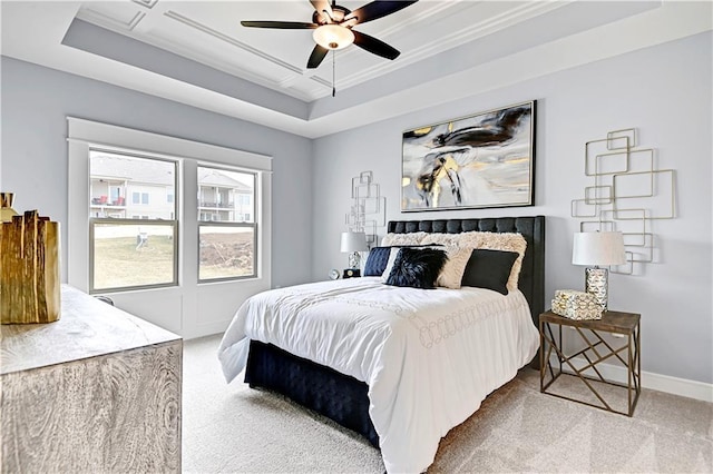 bedroom with coffered ceiling, ceiling fan, ornamental molding, a tray ceiling, and carpet floors