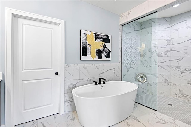 bathroom featuring separate shower and tub and tile walls