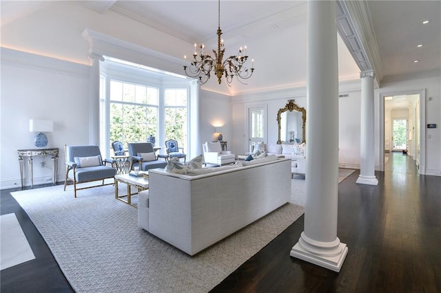 living room with crown molding, dark wood-type flooring, an inviting chandelier, and decorative columns