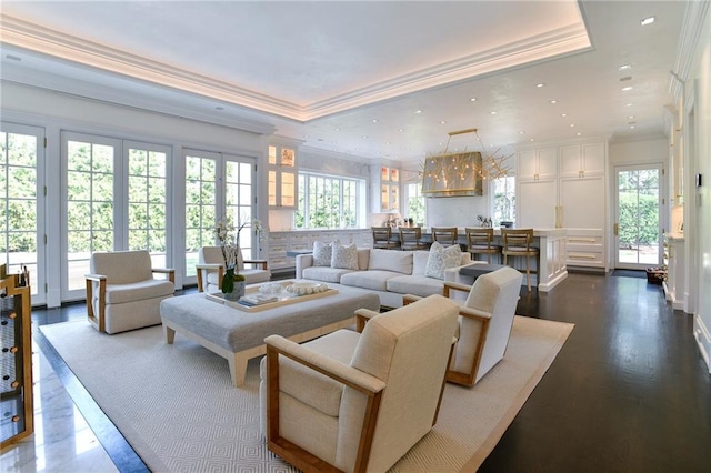 living room featuring a raised ceiling, ornamental molding, and dark hardwood / wood-style floors