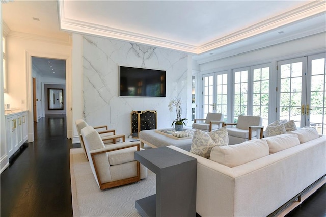 living room with crown molding, dark wood-type flooring, french doors, and a high end fireplace